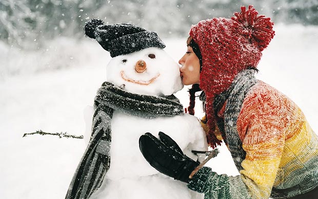 Girl kisses snowman