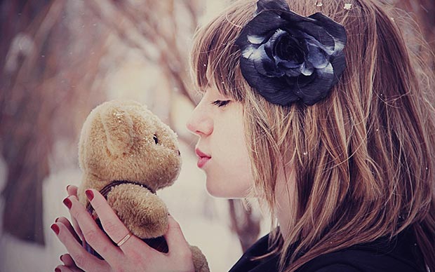 She kisses her teddy bear
